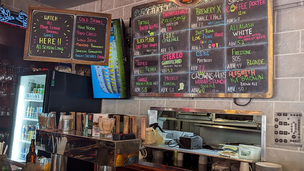 The hand-lettered craft beer chalkboard wall at Standard Station, listing the rotating taps in colored chalk