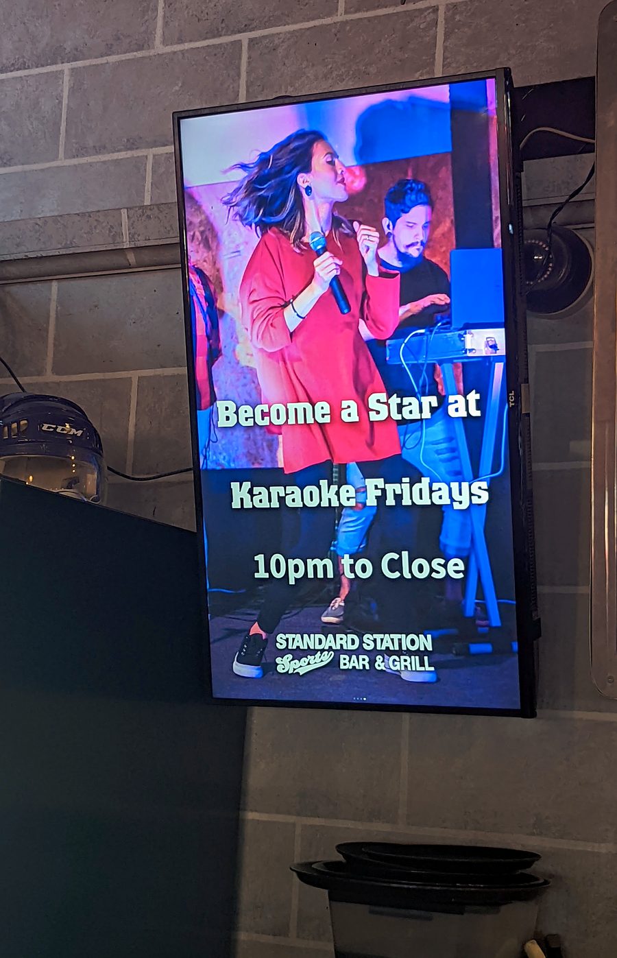 A house screen at Standard Station showing the Karaoke Fridays promo, a singer with a microphone and the venue name at the bottom